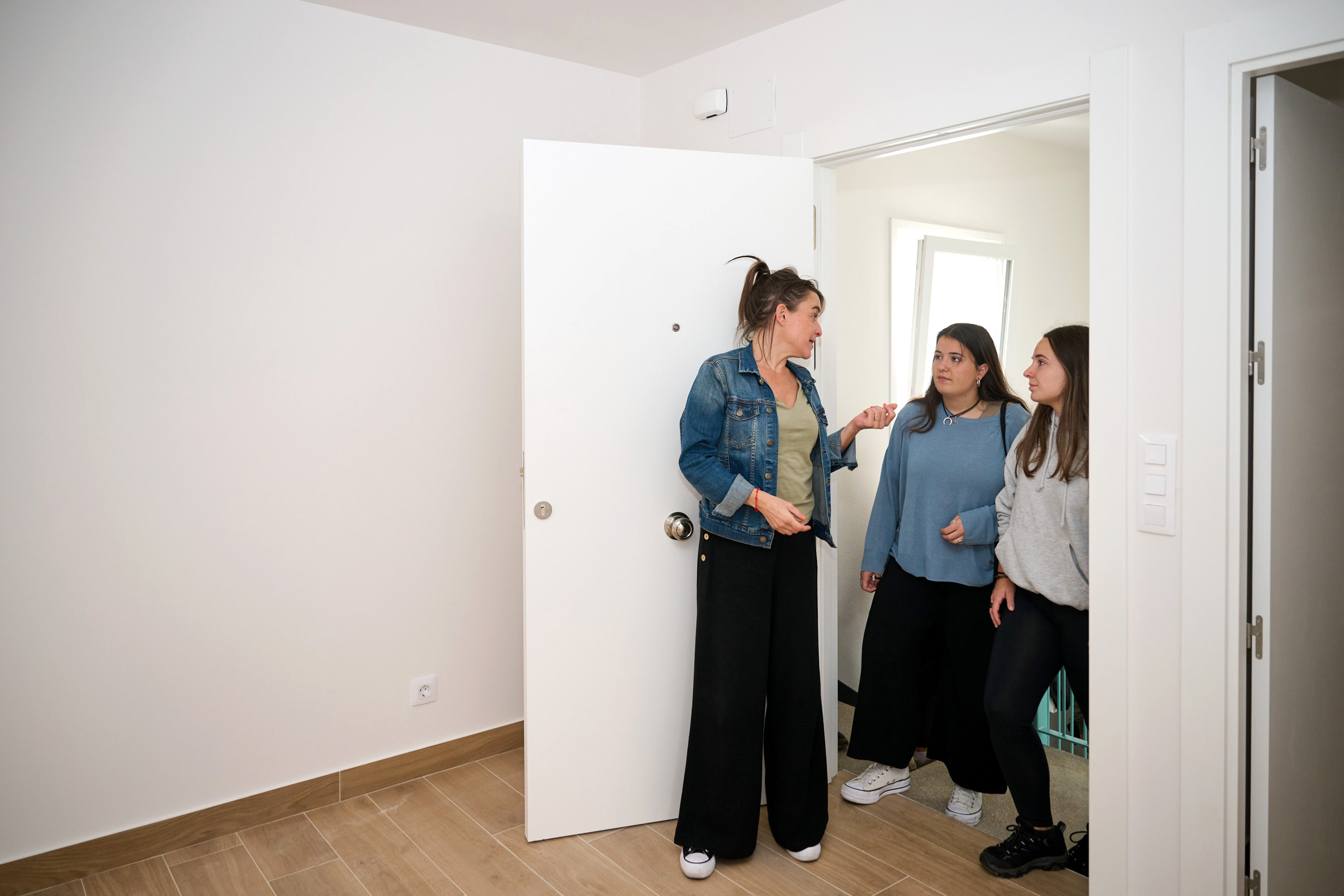 Consejera de Vivienda junto con dos jóvenes visitando las viviendas